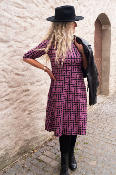 trikåklänning med rosa lila grafiska små cirklar i ekologisk bomull. trekvarts långa ärmar, rund hals och längd till vaden, lös passform från under byst och nedåt. klänning från märket Esther & Inez